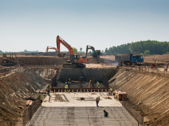 Máquinas pesadas e trabalhadores da construção civil que trabalham em um edifício - mão de obra