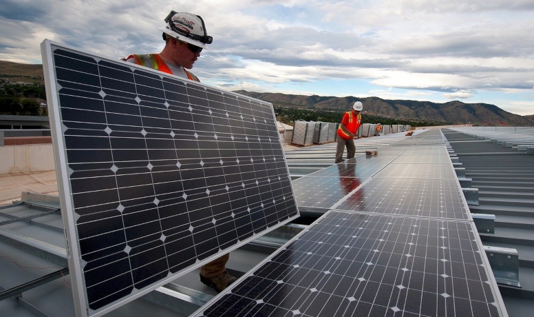 Imagem de trabalhadores da construção civil manuseando paineis solares