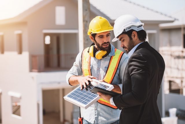 Trabalhadores da construção civil estão trabalhando no canteiro de obras com célula solar no novo canteiro de obras do projeto.