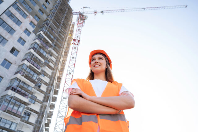 Mulher no canteiro de obras com os EPIs