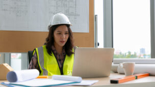 Mulher no escritório fazendo a gestão no canteiro de obras