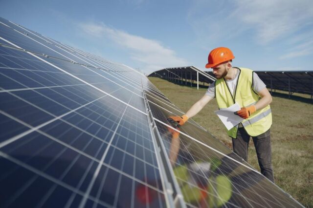 Imagem do trabalhador da construçao civil analisando uma placa solar