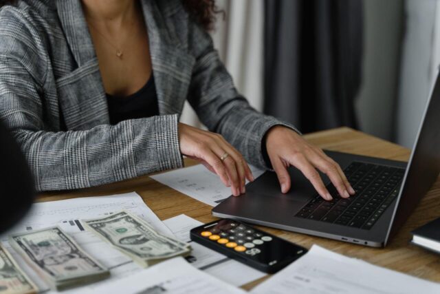 Imagem de mulher digitando no computador e verificando o custo de mão de obra
