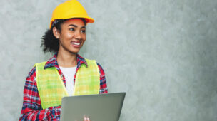 Retrato de jovem profissional engenheira civil trabalhadora de arquitetura usando capacete de segurança